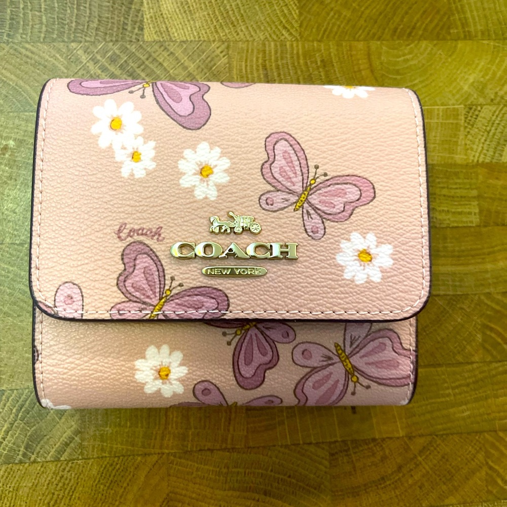 Coach butterfly wallet in pink and purple hues.